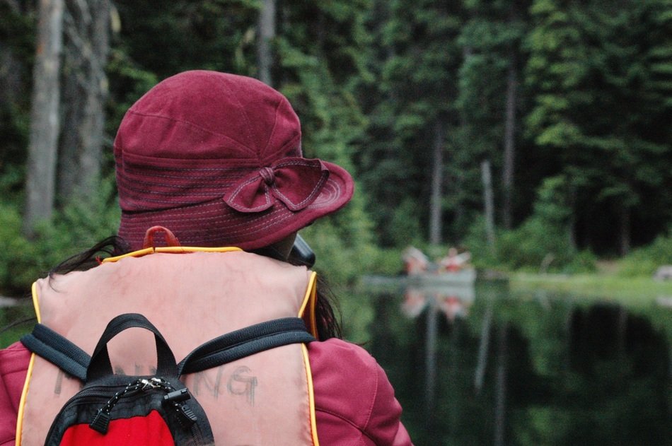 girl in a cap and a backpack on the lake