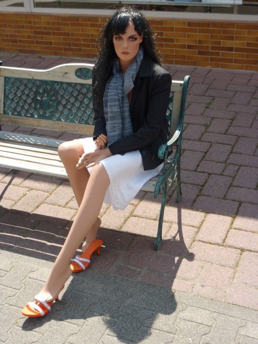 dummy of the woman sitting on a bench