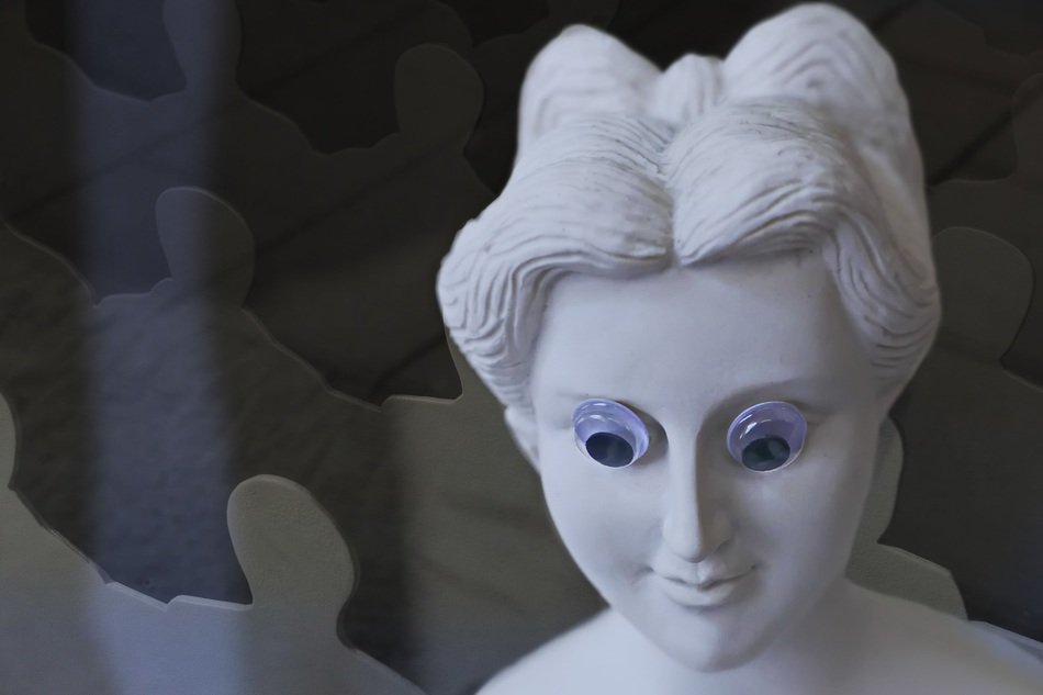 sculpture of woman's face with someone else's eyes