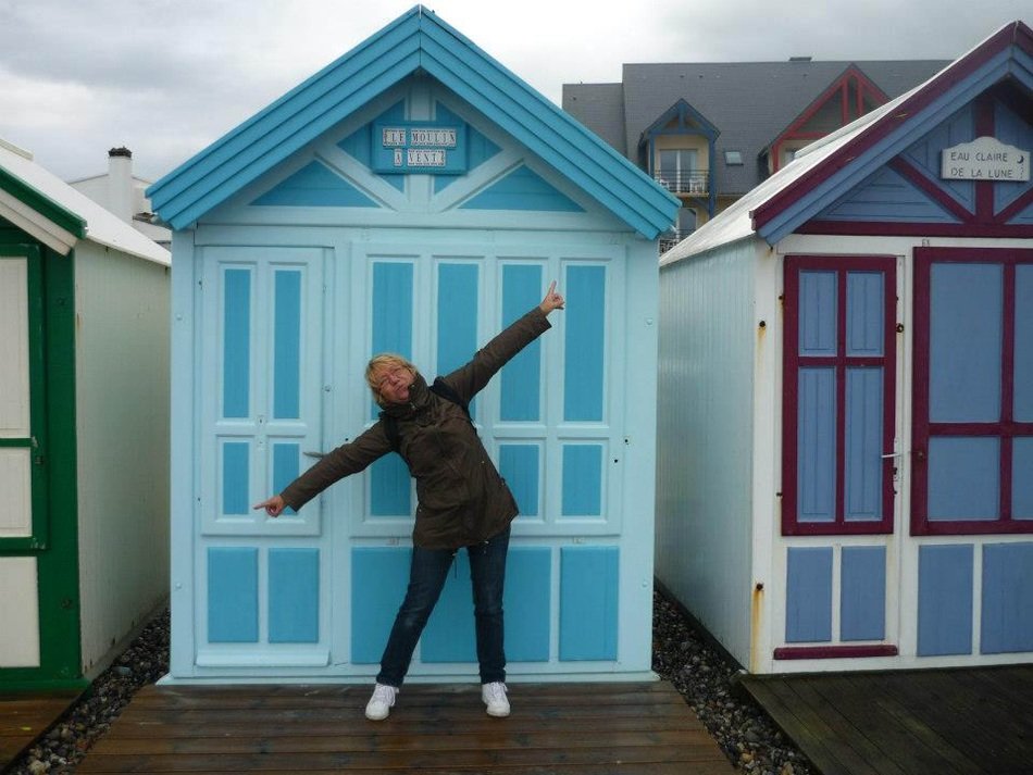 woman with open arms on the background of colorful houses