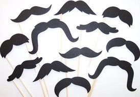black mustache of different types on wooden sticks