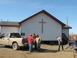 people and a parked car near the church