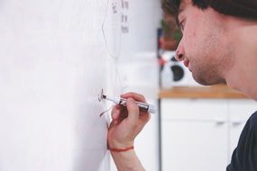 man writing on whiteboard