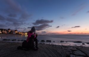 girl playing smartphone on seashore