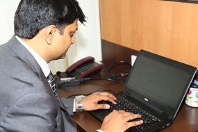 businessman typing on the black laptop