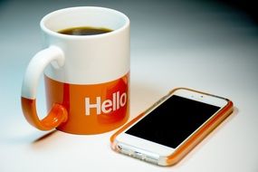 white-orange cup and telephone