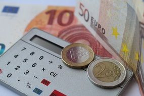 calculator, euro bank notes and coins