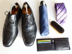 shoes, a tie, a brush for shoes, purse and umbrella