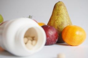 tablets in a jar and fruit