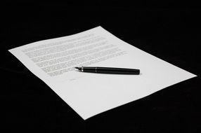 document and pen on a black background