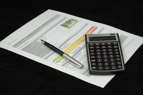 calculator and pen lie on a sheet of paper