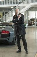 businessman in coat in car showroom