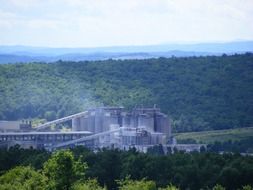 distant view of a cement plant among the forest