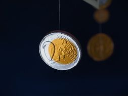 coins hanging on a fishing line