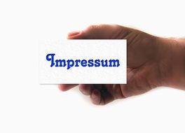 a card of impressum in the hand