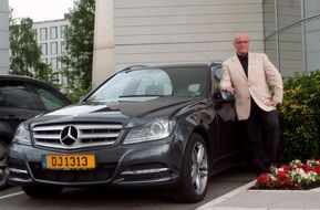 businessman is staying near the mercedes auto