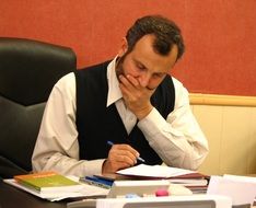 man draws up documents at the table