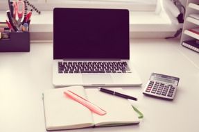 laptop, calculator and notebook for records