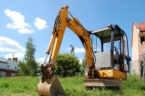 yellow excavator on the lawn