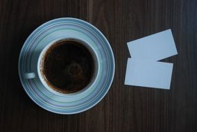 a top view on a cup of coffee and business cards on the table