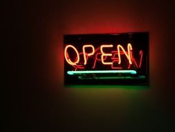 open, neon sign in darkness