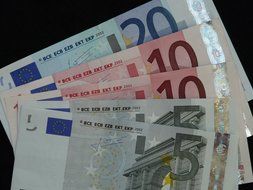 Different euro banknotes on a black background