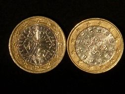 two euro metal coins on a black background