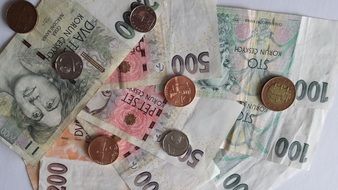 coins on background of the czech crown banknotes