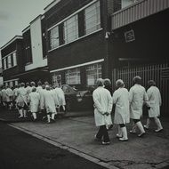 crowd of medical workers on the street, old black and white photo