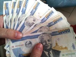 thai money, baht bills in hands