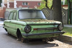 severely damaged old green car