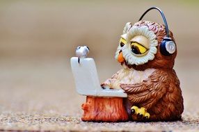 toy owl with headphones and laptop