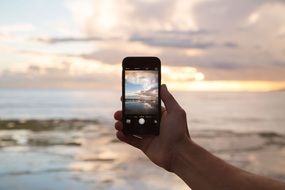 phone in hand against the sea