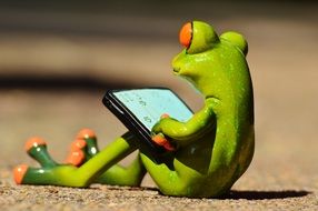 Figurine in the form of a frog at the computer