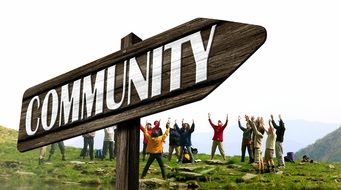 a group of people on a hill behind a sign