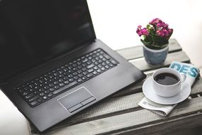 laptop and cup of coffee on a newspaper