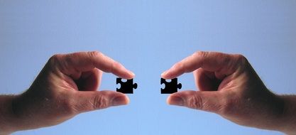 two fitting puzzle pieces in hands