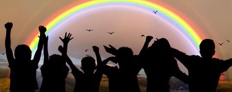 children's silhouettes on a rainbow background in World Children's Day