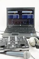 mixer, microphone and headphones on a background of the laptop with the software