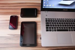 Laptop, smartphone, mobile phones on a wooden table