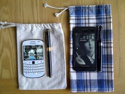 smartphone and blackberry lie on fabric covers