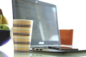 laptop computer and cup at table