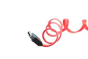 Red swirling cable with black plug on white background