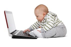 Baby behind laptop