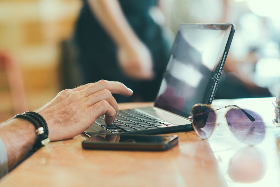 laptop mobile glasses man hand on table