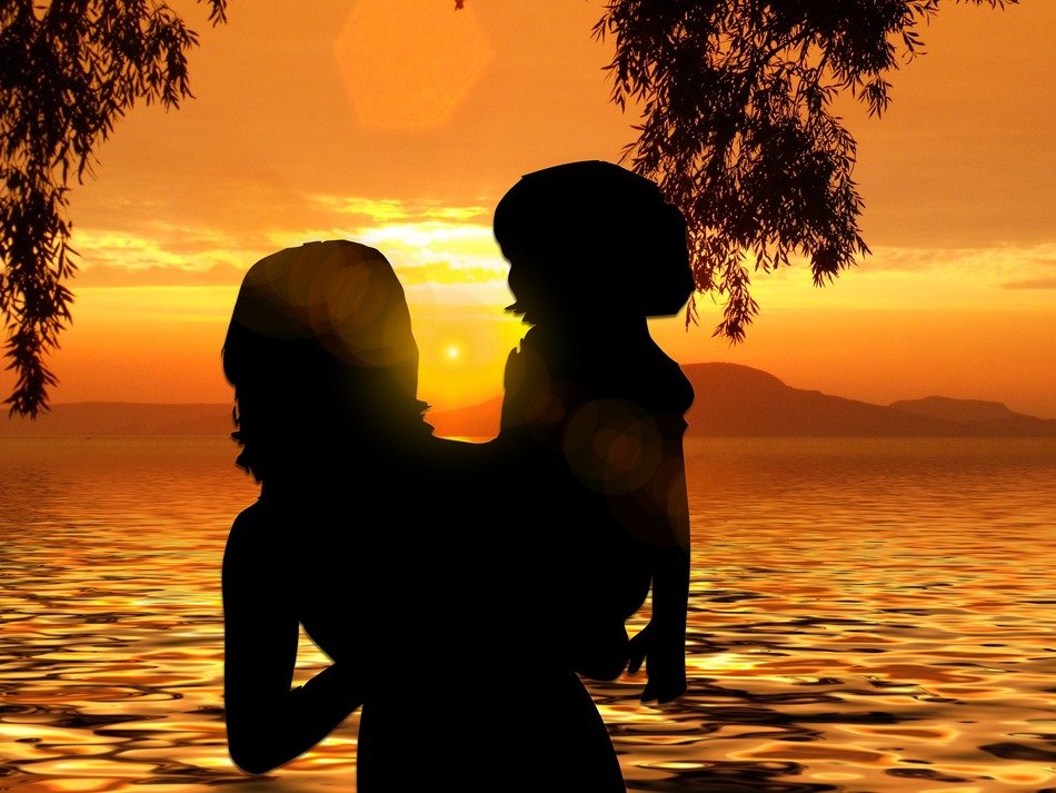 picture of Mother with child on the background of sunset on the beach