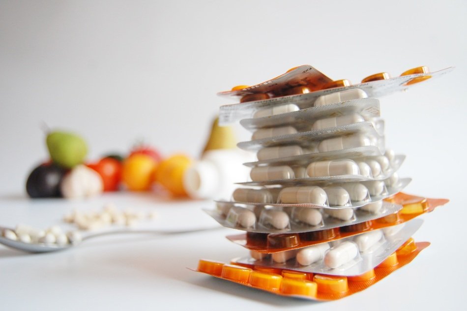 blisters of pills on a background of vegetables and fruits