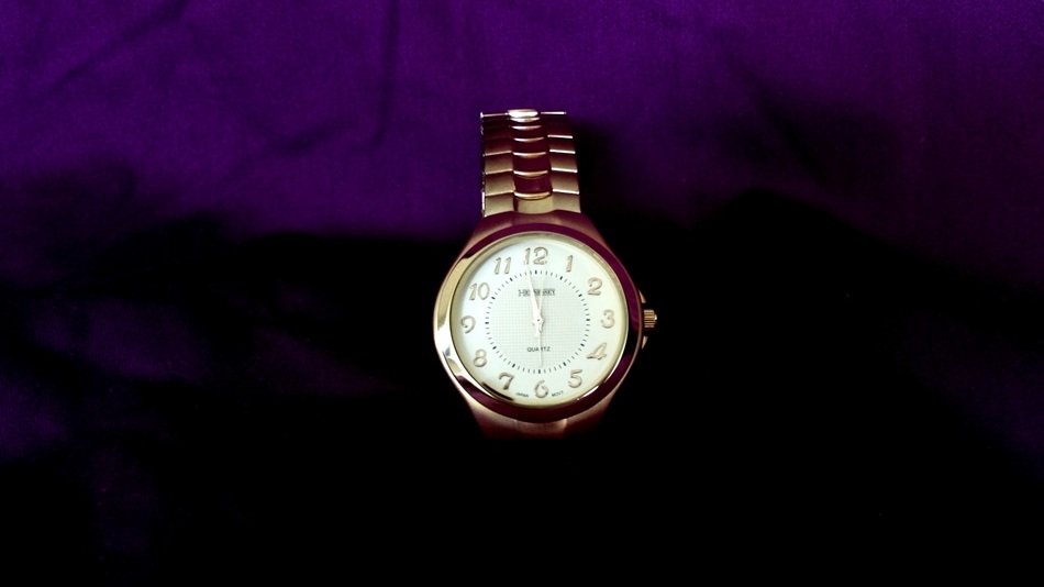 gold watch on a purple stand