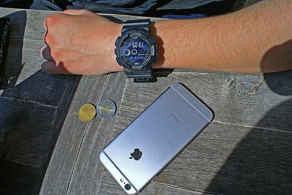 the hand and iPhone are on a table