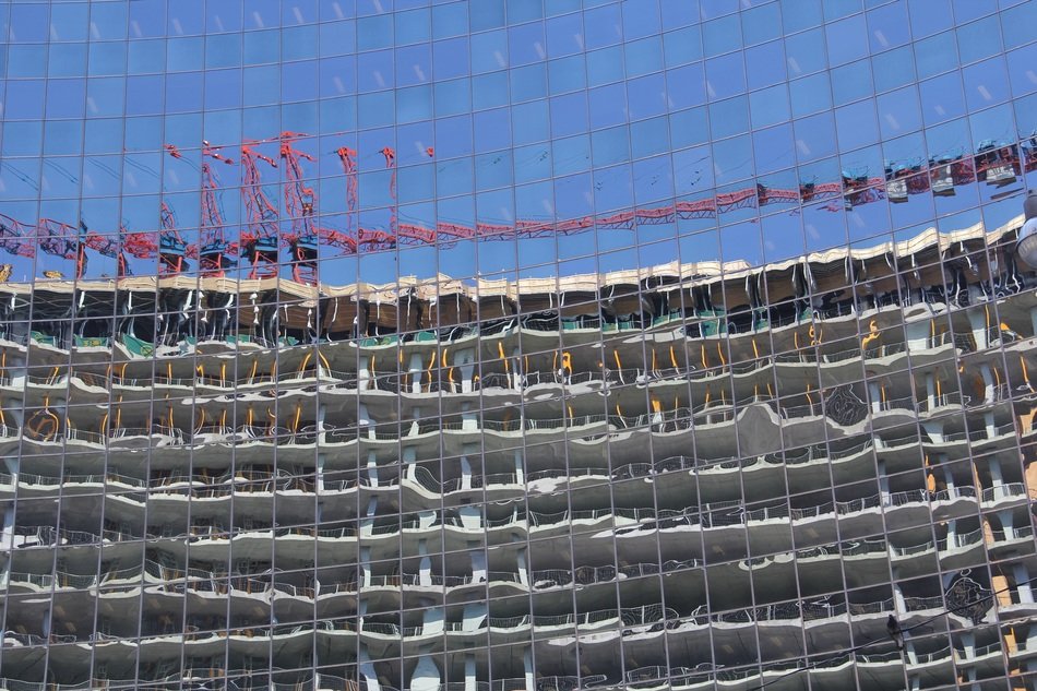 mirroring of building under construction and crane